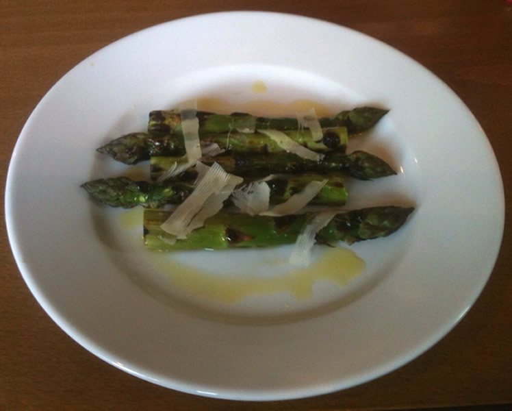 Grilled asparagus with sauce and cheese shavings